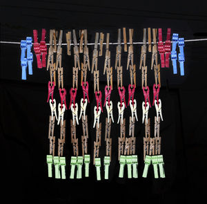 Close-up of clothespins hanging against black background