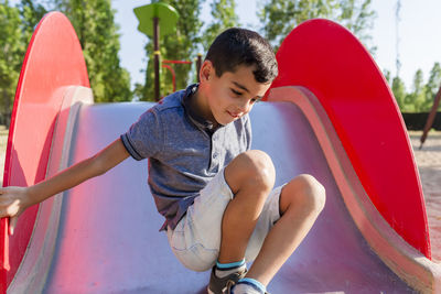 Little boy having fun playing in the playground in a park.