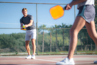 Rear view of man playing tennis