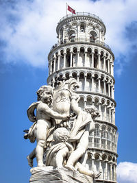 Low angle view of statue of building against cloudy sky