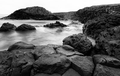 Rocks in sea against sky