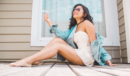 Fashionable smiling woman sitting outdoors