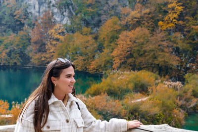 Happy young woman in plitvice lakes national park in croatia in autumn