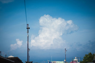 Low angle view of electricity pylon against blue sky