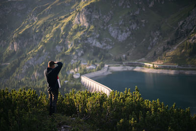 Man standing by lake against mountains