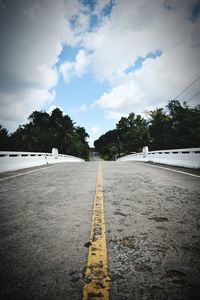 Surface level of road against trees and sky