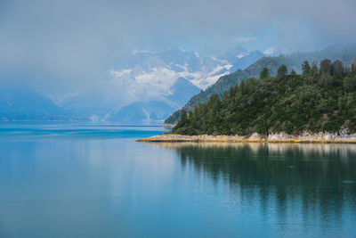 Scenic view of lake by mountains against sky