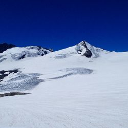 Scenic view of snowcapped mountains against clear blue sky