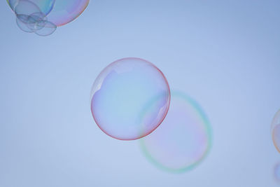 Low angle view of bubbles against blue background