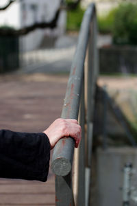 Close-up of hand holding metal railing