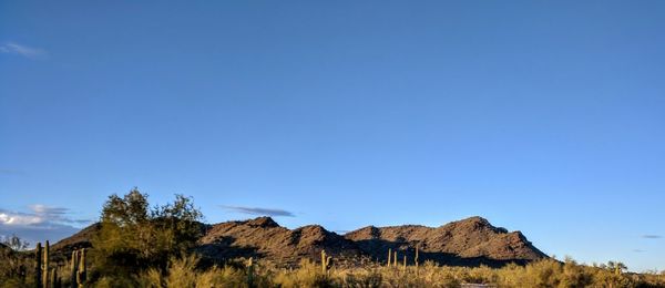 Scenic view of mountains against blue sky