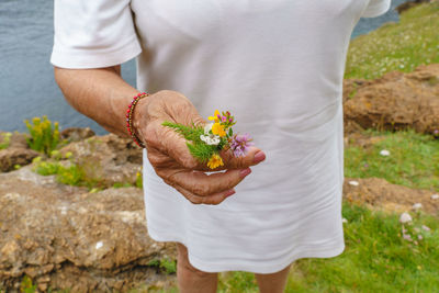 Midsection of man holding flower bouquet