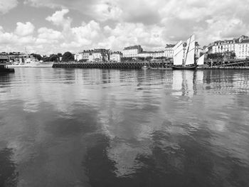 River by buildings in city against sky