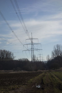 Electricity pylon on field against sky