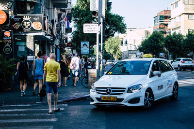 Rear view of people walking on city street