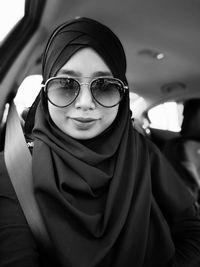 Portrait of mid adult woman wearing sunglasses while sitting in car