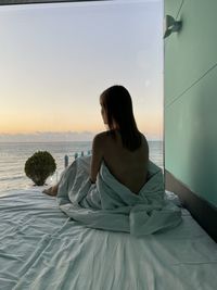 Portrait of young woman standing at beach
