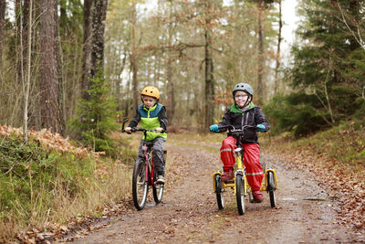 Boys cycling through forest