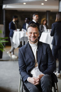 Portrait of smiling disabled businessman sitting in wheelchair at seminar