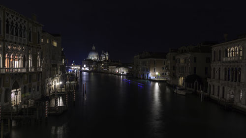 Canal passing through city buildings at night