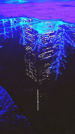 High angle view of illuminated city by sea