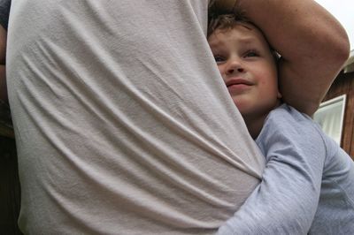 Low angle view of boy embracing father