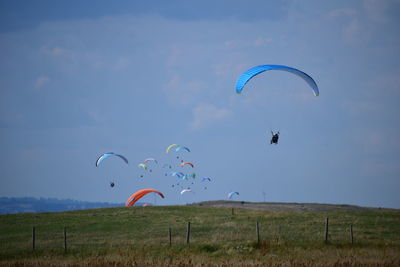 Kite flying over field against sky