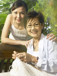 Portrait of smiling mother and daughter at back yard