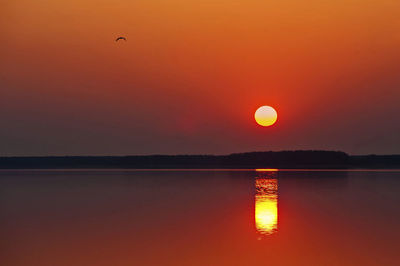 Scenic view of lake against romantic sky at sunset