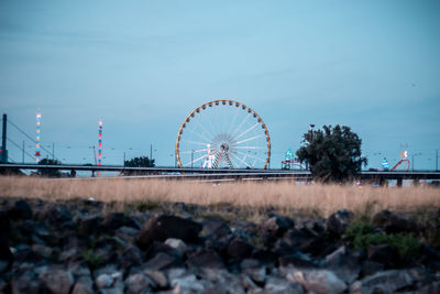 Ferris wheel on field against sky