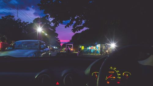 Cars on illuminated street at night