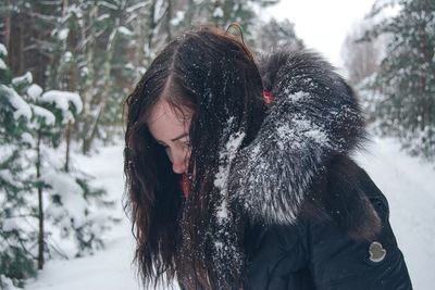 Woman wearing warm clothing in forest during winter