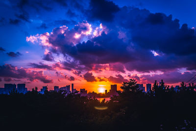 Silhouette buildings against sky during sunset