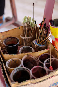 High angle view paintbrushes in disposable cup in box