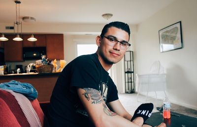 Portrait of smiling young man sitting at home