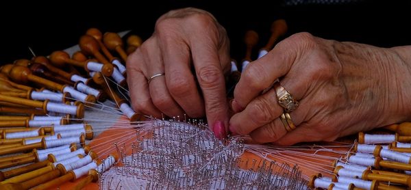Cropped hands of senior woman working with thread and needle