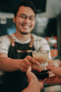 Midsection of a man drinking glass in restaurant