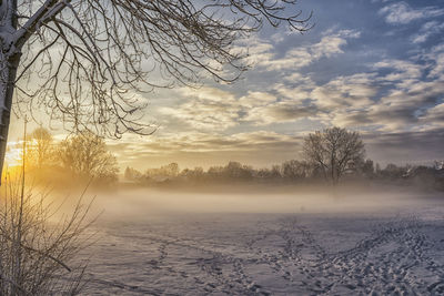 Scenic view of frozen landscape against sky during winter