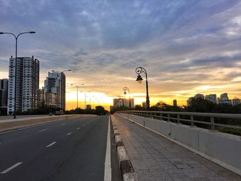 View of city street against cloudy sky