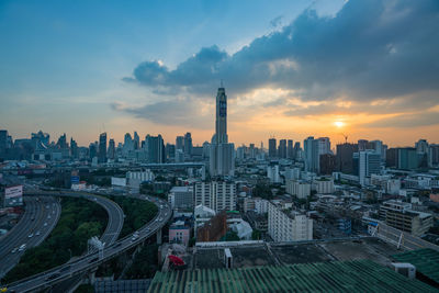 Aerial view of buildings in city during sunset