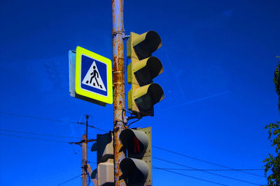 Low angle view of road sign against blue sky