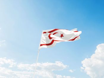 Low angle view of flag against blue sky