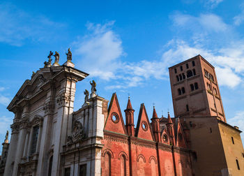 Low angle view of cathedral by building against blue sky