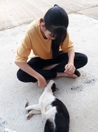 High angle view of girl with cat sitting on floor