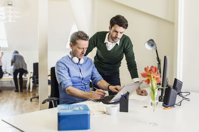 Businessmen using laptop in office