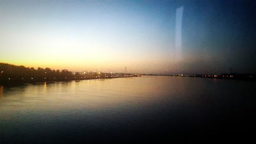 Scenic view of river against sky at sunset