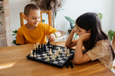 Happy boy playing on chess board
