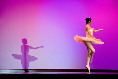 Side view of female ballet dancer performing on stage