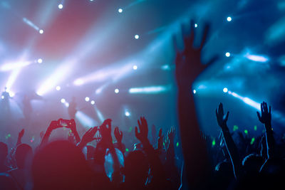 Crowd with arms raised enjoying at music concert