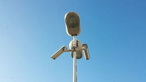 Low angle view of electric lamp against clear blue sky